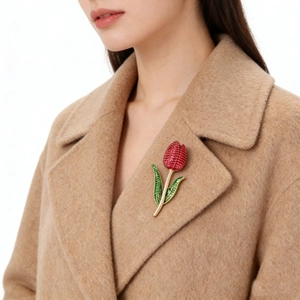 Close-up of tulip brooch with red crystals on camel coat lapel, elegant floral pin