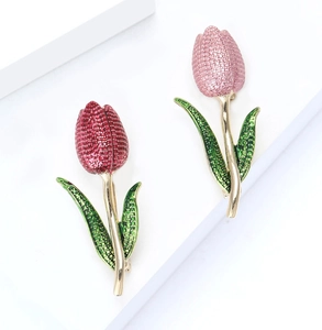 Close-up of pink and red enamel tulip brooches with gold stems and green leaves
