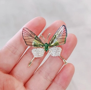 Detail der Schmetterlingsbrosche mit rosa Acrylflügeln und grünem Edelstein-Inlay