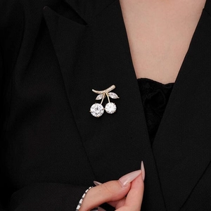 Elegant cherry fruit brooch with white zircons on a black blazer jacket for women