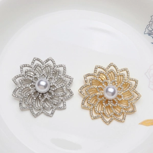 Broche fleur élégante en alliage ajouré avec strass brillants et perle blanche centrale