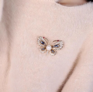 Broche papillon exquise en perles et émail avec cristaux sur un pull en maille