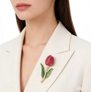 Detailed view of tulip brooch with red and green rhinestones on a beige blazer lapel