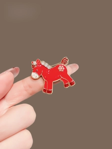 Detailansicht der roten Emaille-Pony-Brosche mit Goldrand und Strasssteinen