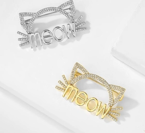 Détail de broches chat meow avec incrustations de zircons étincelants en or et argent