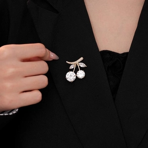 Elegant crystal cherry brooch with gold plating on black suit jacket for women