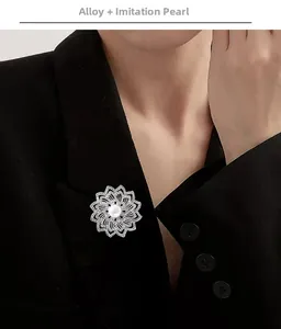 Détail d'une broche florale argentée avec perles et strass sur une veste de costume