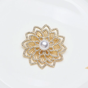 Broche fleur dorée élégante avec une grande perle centrale et des strass étincelants