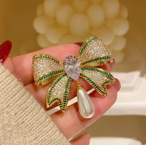 French vintage luxury bow brooch with green crystals and a teardrop pearl pendant