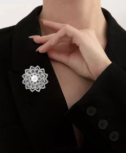 Élégante broche fleur avec perles et strass épinglée sur le revers d'un tailleur