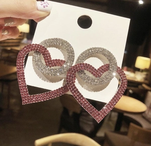 Exaggerated silver needle earrings with pink heart crystals and sparkling rhinestones