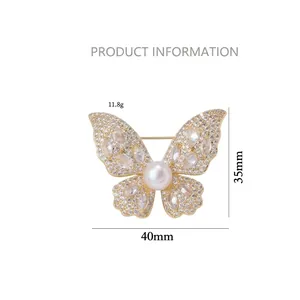 Elegant gold butterfly brooch with glittering crystals and large pearl, 40mm wide