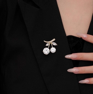 Exquisite cherry brooch with crystal stones pinned on a black suit lapel closeup