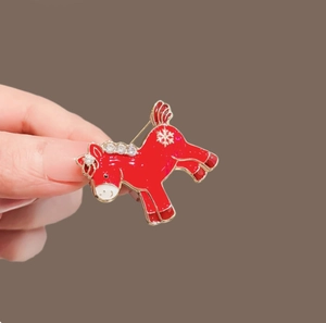 Funkelnde rote Pony-Brosche mit Strasssteinen und Schneeflocken in festlichem Goldmetall