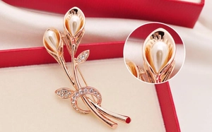 Close-up of rose gold calla lily brooch with white pearls and sparkling crystals