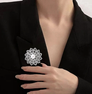 Détail de la broche tournesol avec grande perle et zircons brillants sur blazer noir