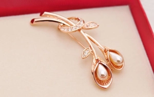Detail of rose gold tulip brooch with white pearls and sparkling zircon accents