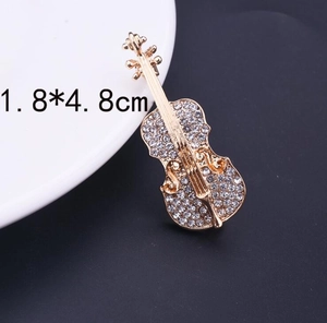 Detaillierte Nahaufnahme einer Gold-Violinen-Brosche mit Strasssteinen und 1,8x4,8 cm Maß