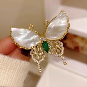 Elegante broche de mariposa dorado con nácar blanco, gema verde y cristales brillantes
