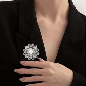 Élégante broche fleur en alliage avec strass et perle blanche sur un costume noir classique