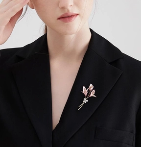 Broche fleur de lys élégante avec émail rose sur un blazer noir professionnel chic
