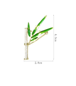 Dettaglio macro della spilla a bambù con smalto verde e cristalli, misura 4,3cm per 2,8cm