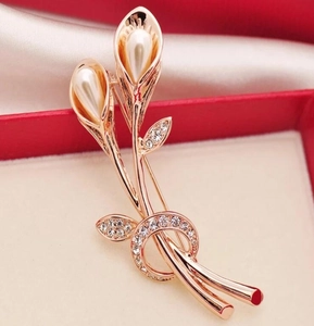 Detailed macro view of tulip brooch with white pearls and crystals in a jewelry box