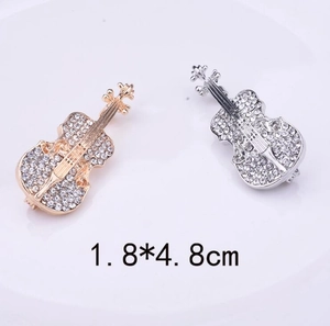 Makroansicht von Geigenbroschen in Gold und Silber mit Strasssteinen und 1,8 x 4,8 cm Maß