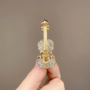 Eleganter Geigen-Anstecker aus goldfarbenem Metall mit funkelnden Strasssteinen