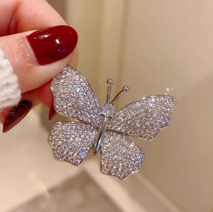 Close-up of elegant silver butterfly brooch with sparkling crystals and shimmering diamonds