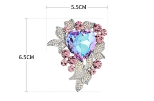 Detail showing high-end heart-shaped brooch with blue-purple crystal and pink accents