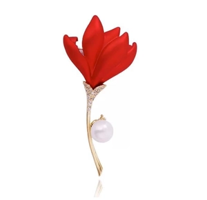 Détail de la broche fleur rouge avec tige dorée, perle blanche et cristaux scintillants