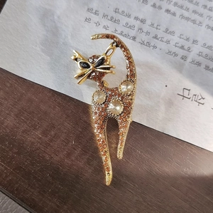 Macro shot of amber rhinestone cat brooch with gold metal finish and sparkling crystals