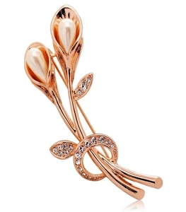 Close-up of a rose gold calla lily brooch with white pearls and sparkling crystals