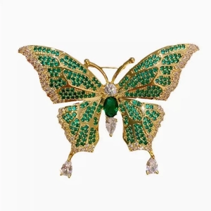 French vintage butterfly brooch with emerald green stones and gold finish on white
