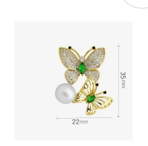 Detailansicht der 35mm Gold Schmetterlingsbrosche mit grünen Steinen und weißer Perle