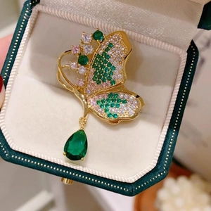 Spilla farfalla dorata con zirconi color smeraldo e pendente a forma di goccia