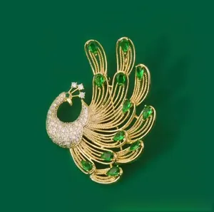 Detailed macro view of the gold peacock brooch with emerald crystals and pavé rhinestones