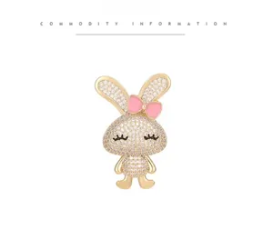 Détail d'une broche lapin dorée ornée de strass et d'un petit nœud rose élégant