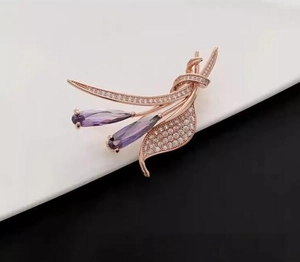 Détail macro de broche fleur or rose avec cristaux violets et sertissage de zircons