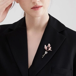 Élégante broche fleur de lys rose avec zircons sur le revers d'un costume noir