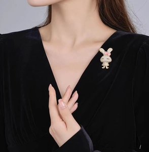 Gros plan d'une broche lapin étincelante avec strass sur une robe en velours noir