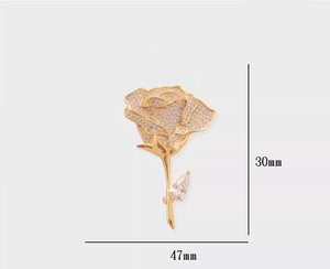 Detail view of crystal pavé rose brooch in gold finish with 30mm x 47mm dimensions