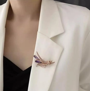 Détail d'une broche en épi dorée rose avec pierres violettes et zircons blancs