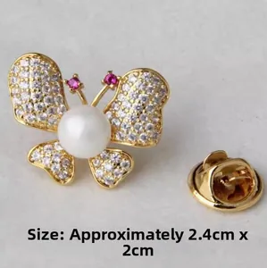 Détail macro d'une broche papillon avec zircons et perle, taille 2,4cm x 2cm