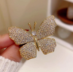 Macro shot of French style golden butterfly brooch with sparkling crystals and fine details