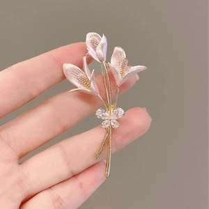 Broche lys dorée élégante avec pétales rose nacré et nœud papillon en zircon scintillant