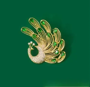 Detailed macro view of an elegant gold peacock brooch with emerald green teardrop crystals
