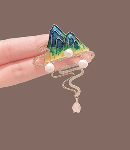 Detail view of enamel landscape brooch with pearls, tassel pendant and sparkling crystals