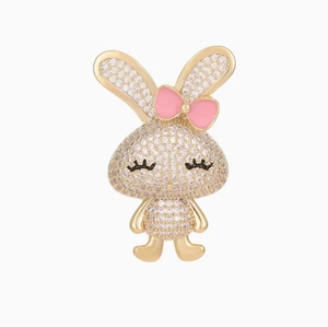 Détail d'une broche lapin avec pavage de cristaux blancs et un nœud en émail rose
